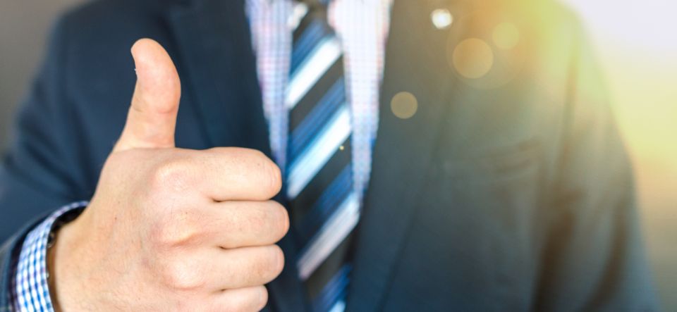 man in suit giving thumbs up sign