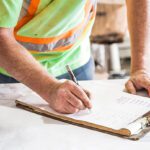 construction worker writing on clipboard
