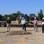 five men holding shovels at a groundbreaking ceremony