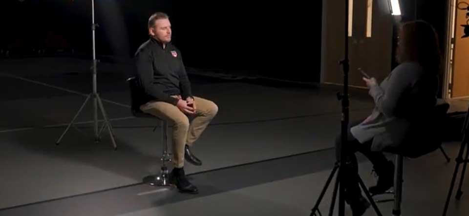 man sitting on stool in front of cameras