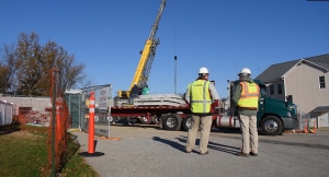 two men on construction site behind crane