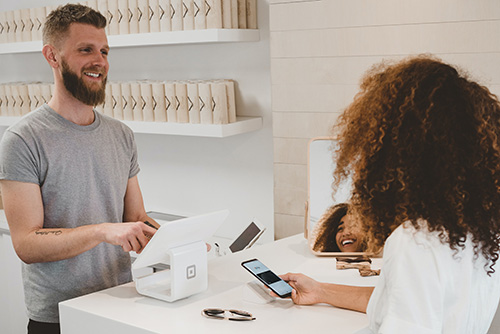 woman in white shirt at register with man in gray shirt