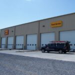 Front garage door view of the commercial truck showroom with a truck sitting in front of it
